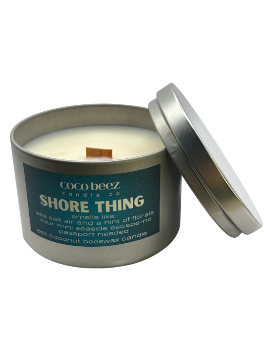 Travel tin candle with Shore Thing on the label