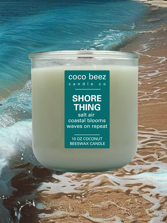 A 10 oz coconut beeswax candle by Coco Beez Candle Co. in a clear glass jar, labeled 'Shore Thing'.
