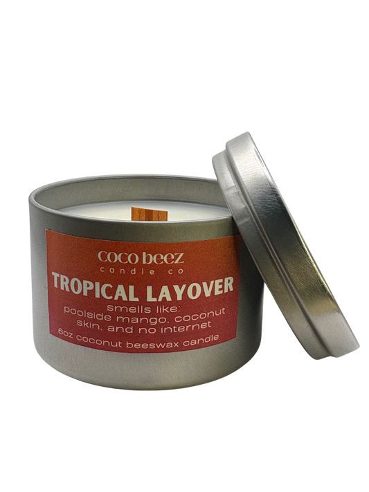 Coco Beez candle in a metal tin labeled 'Tropical Layover' 